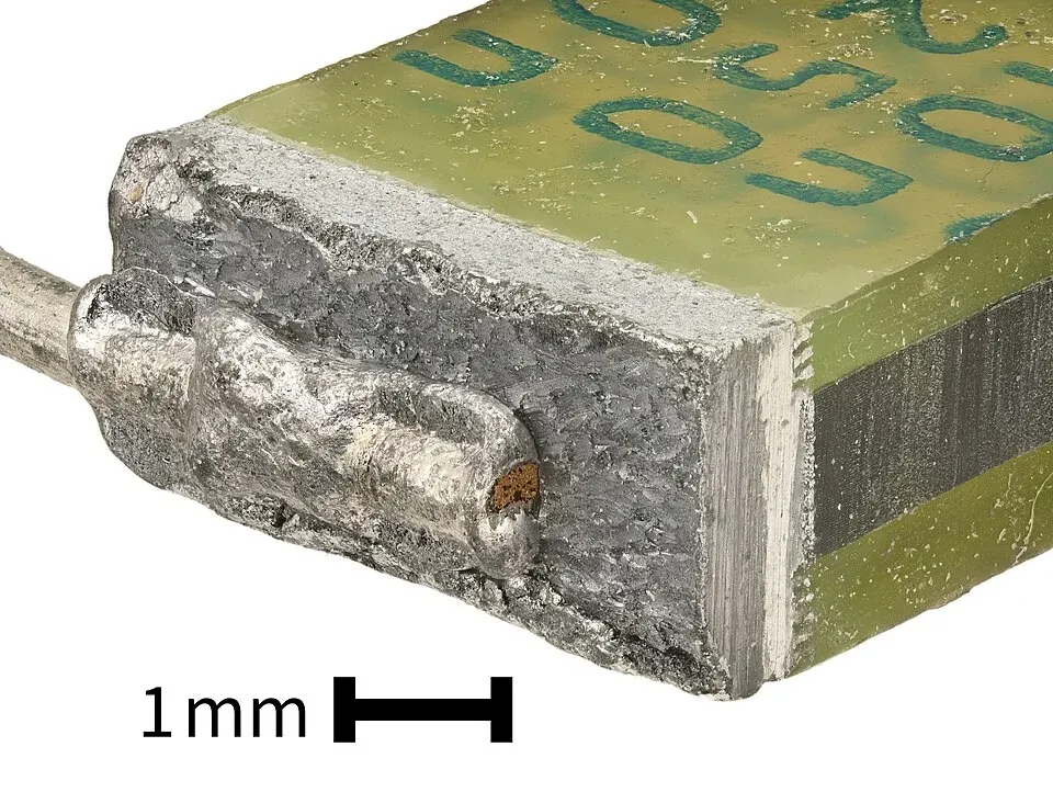 Exposed film capacitor end showing the sprayed metallized connection and terminal