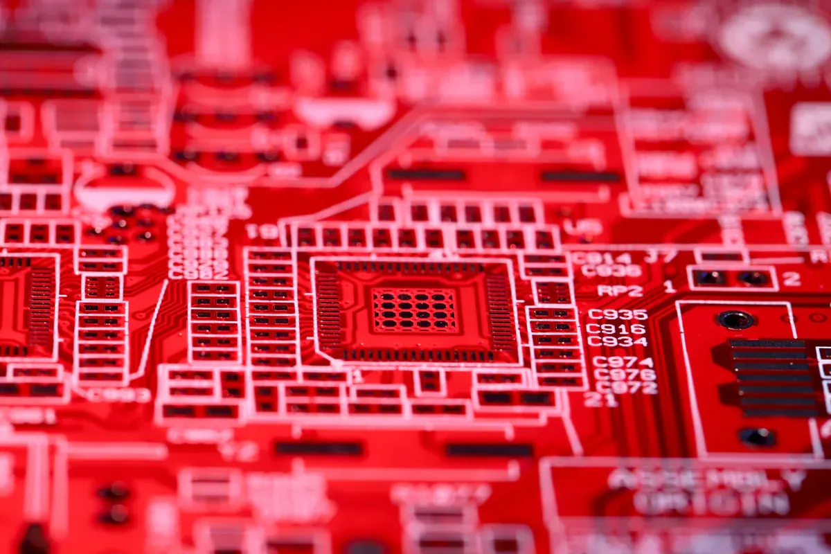 Unpopulated integrated-circuit footprints and copper traces on a red circuit board