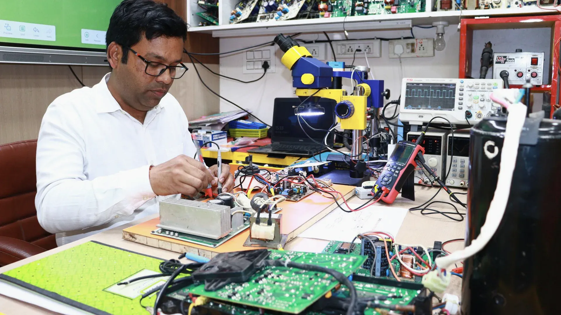Engineer testing a populated circuit board with probes and bench instruments