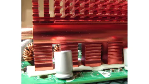 Compressible thermal gap pad bridging an electronic assembly and a copper heatsink
