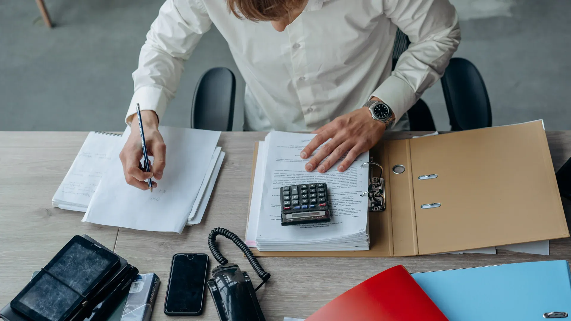 Procurement documents and electronic components reviewed at a worktable