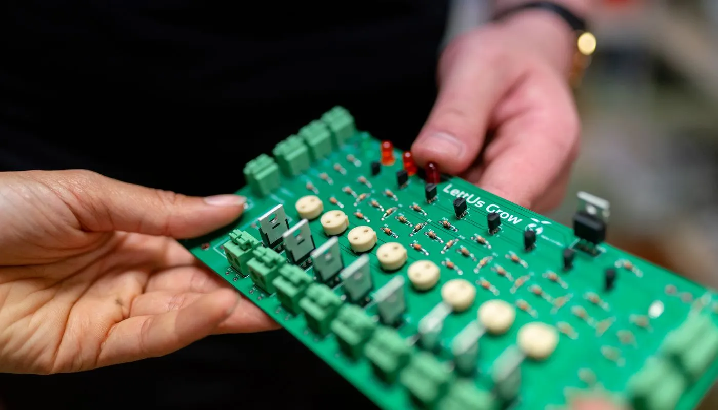 Hardware engineers inspecting an electronic circuit board for a connected device