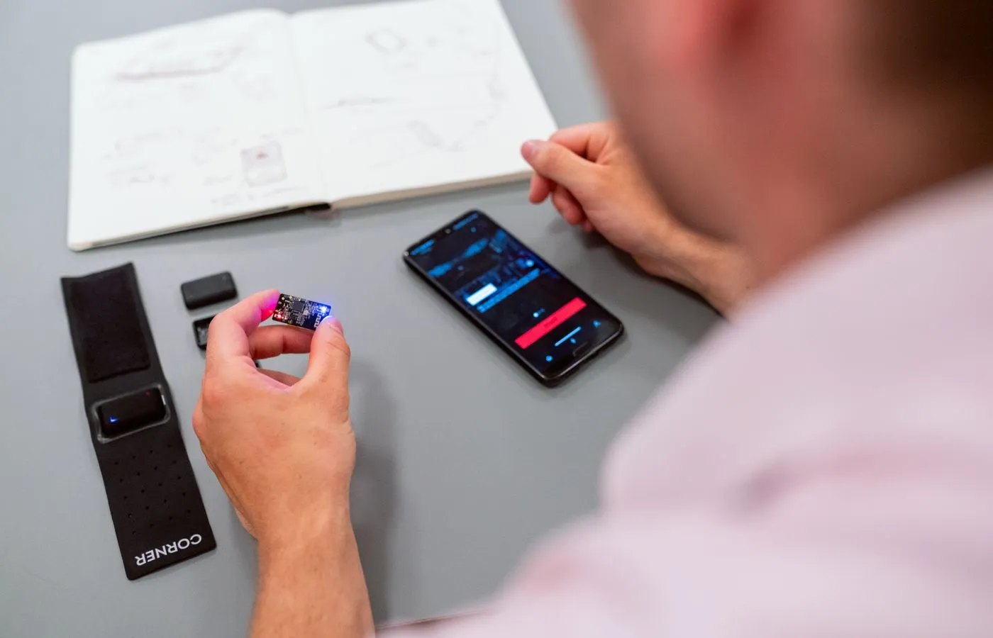 Engineer testing a wearable electronics prototype and connected mobile application